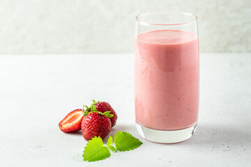 Refreshing mint strawberry smoothie, yogurt milkshake in glass with mint leaves.