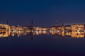 Fototapeta premium The reflection of the city center onto the water at night in Germany. The northern German city at night in Summer