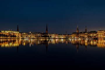 Obraz premium The reflection of the city center onto the water at night in Germany. The northern German city at night in Summer