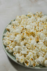 Plate of popcorn on a light background