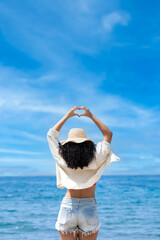 Pretty young girl on the seashore with beach hat	