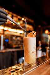 delicious refreshing cocktail with fresh grapefruit and fragrant mint in a beautiful glass cup with a black straw in a cozy nice café