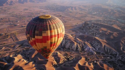 Obraz premium view of hot air balloons floating over desert red sand dunes as the sunset paints the sky with vivid colors.
