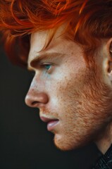 Obraz premium Close-up profile portrait of a handsome man with red hair looking away.