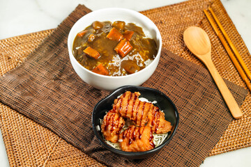 Japanese Deep Fried Chicken and Curry Rice with chopsticks and spoon served in bowl isolated on napkin side view of Japanese food