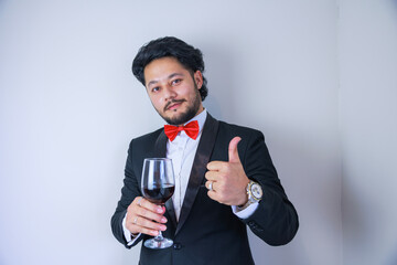 ワインを片手にGoodサインをする男性