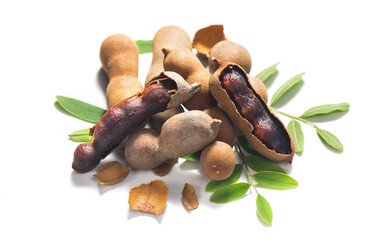 Tamarind tropical fruits isolated on white background. Fresh Tamarind pods with leaves (Tamarindus indica, Indian date), healthy vegan food close up