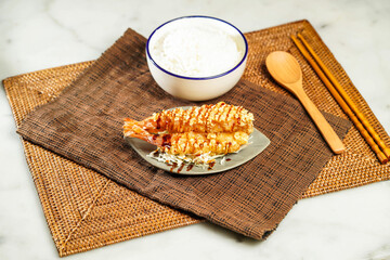 Japanese Deep Fried Shrimp Donburi with Rice, chopsticks and spoon served in bowl isolated on napkin side view of Japanese food