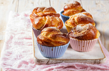 Rose-shaped yeast dough buns sprinkled with sugar in ceramic molds.