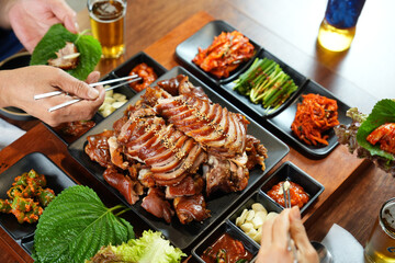 식탁 위에 족발이 플레이팅 된 족발을 젓가락으로 먹는 모습