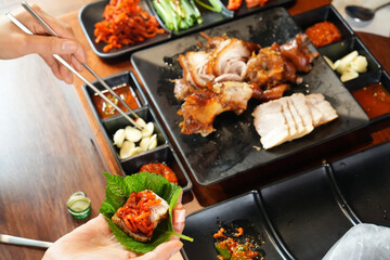 보쌈을 깻잎으로 쌈을 쌓아서 먹는 모습