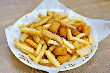 식탁 위에 모듬 감자 튀김이 놓여 있는 모습