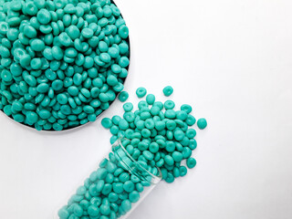 Aruba blue masterbatch granules on white background. Color pigment carrier polymer in plastic...