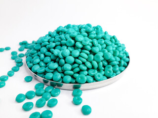 Aruba blue masterbatch granules on white background. Color pigment carrier polymer in plastic...