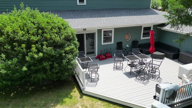 Drone moving down and looking at a newly renovated backyard composite deck.