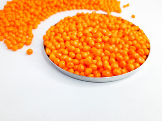Sheer apricot masterbatch granules on white background. Color pigment carrier polymer in plastic industry