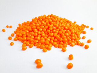 Sheer apricot masterbatch granules on white background. Color pigment carrier polymer in plastic industry