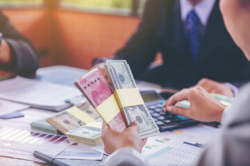 Fototapeta premium Businesswoman holding money banknotes and making decision for business investment. Selected focus 