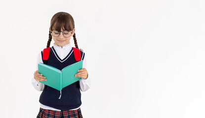 The girl really likes to read an interesting book. Girl in school uniform reading blue book