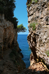 Sea canyon with high sheer cliffs descending to turquoise water. Place for jump in Verudela Canyon in Pula, Croatia
