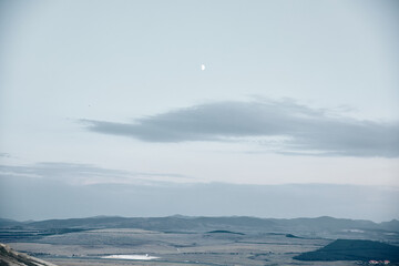 Moonlit desert mountains stunning view of moon rising over rugged mountains from desert hilltop at night