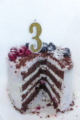 an anniversary chocolate cake on a white background for a three year old