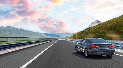 The car is driving along the highway surrounded by picturesque nature.