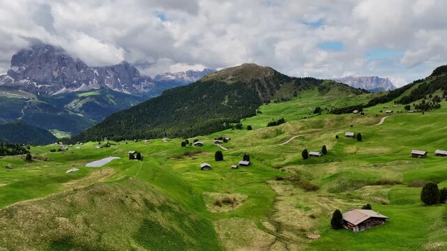 Aerial view of the rocky peaks of the Seceda Mountain touching the clouds in the Dolomites, Italy