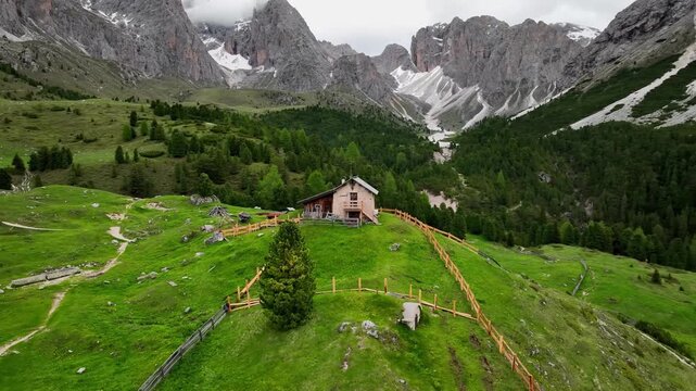 Aerial view of the rocky peaks of the Seceda Mountain touching the clouds in the Dolomites, Italy