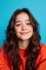 Naklejka premium An Asian Teenager'S Portrait, Isolated In A Blue Studio Background