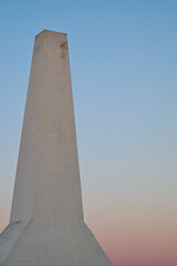 Obraz premium Minimalist Architectural Detail of the chimney of a fish smokery on the Danish island of Bornholm with with Pastel Gradient Sky at Sunset
