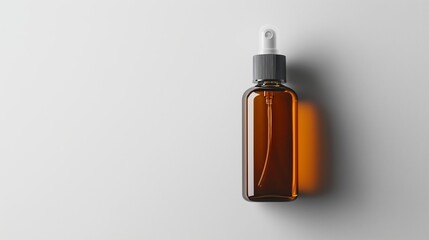 Glass dropper bottle with amber liquid on a white surface