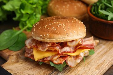 Delicious burger with bacon and cheese on table