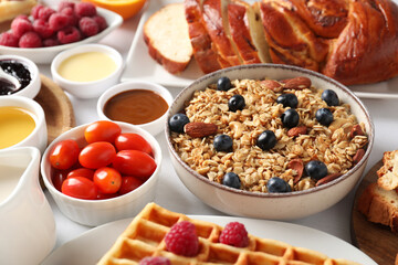 Different meals served for breakfast on white table, closeup. Buffet menu
