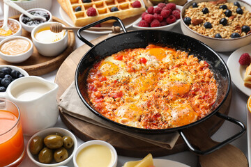 Different meals served for breakfast on white table, closeup