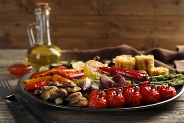 Delicious grilled vegetables served on wooden table, closeup