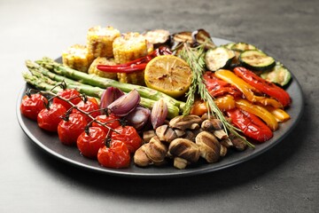 Delicious grilled vegetables on grey textured table, closeup