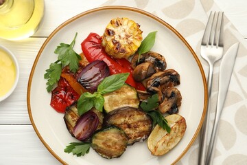 Delicious grilled vegetables with spices served on white wooden table, flat lay