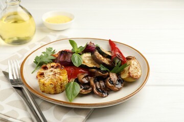 Delicious grilled vegetables with spices served on white wooden table
