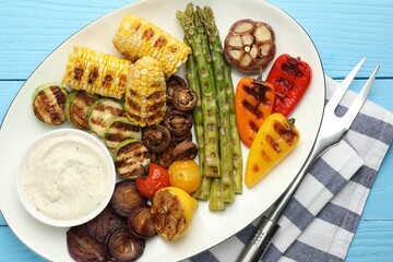 Delicious grilled vegetables served on light blue wooden table, flat lay