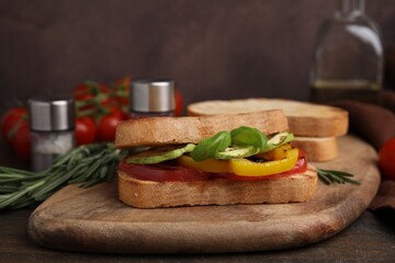 Tasty sandwich with grilled vegetables on wooden table, closeup