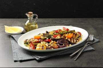 Delicious salad with grilled vegetables served on gray textured table