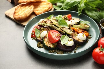 Delicious salad with grilled vegetables on gray textured table, closeup