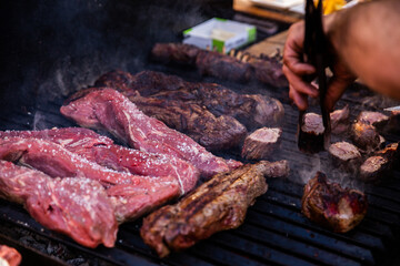 Some excellent pieces of Argentinian beef on a charcoal grill being prepared at open kitchen street...