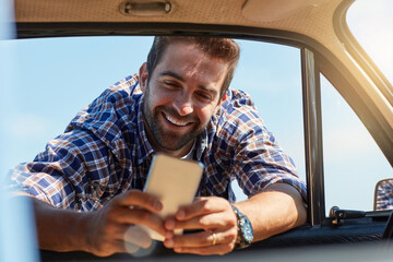 Road trip, break and man with phone by car for summer vacation, adventure or update on journey....