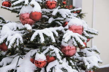 Christmas trees decorated with red balloons in front of the cafe entrance. Street New Year decorations.