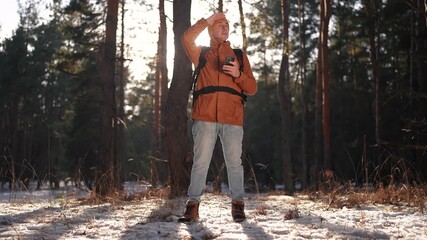 travel navigation. man tourist looking for a way in a smartphone navigation in winter in a forest park. male hacker navigates in the forest navigation looking for a way in winter in park lifestyle