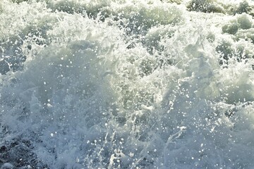 Big waves in the sea. Beautiful sea with splashes under the bright morning sunlight.