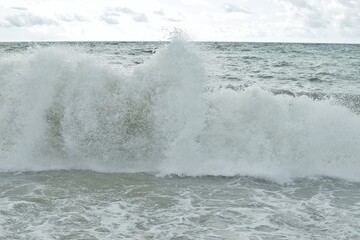 Big waves in the sea. Beautiful sea with splashes under the bright morning sunlight.