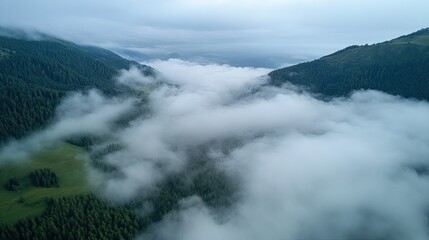 Obraz premium Aerial shot of a mountain landscape with misty clouds, open sky area for text